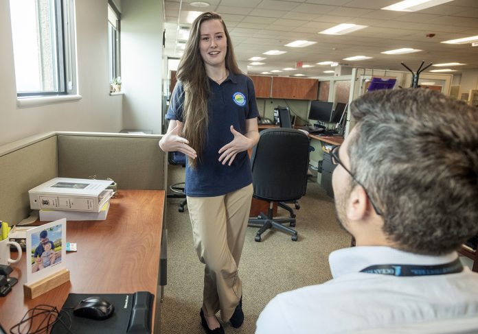 ENERGETIC DISCUSSION: ­Abigail Hasenfus, renewable energy programs manager for the state of Rhode Island, speaks with Derek Gomes, chief public affairs officer for the R.I. Office of Management and Budget. PBN PHOTO/MICHAEL SALERNO