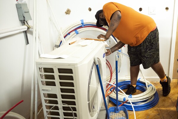 A student works on a training unit during one of Jackie Robinson's classes at the Energy Coordinating Agency, a nonprofit focused in part on energy equity, on Tuesday, July 2, 2024, in Philadelphia. (AP Photo/Joe Lamberti)