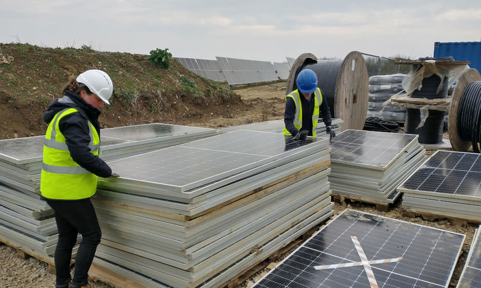 Image of two people examining damaged solar panels for potential recycling.