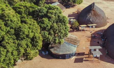 Solar panels next to huts in an aerial view of Piyulaga village