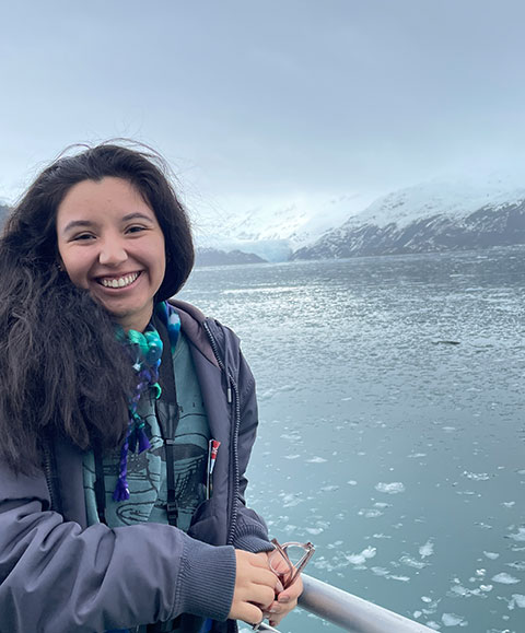 Paula Pérez on the deck of a boat, with an icy ocean behind her. 