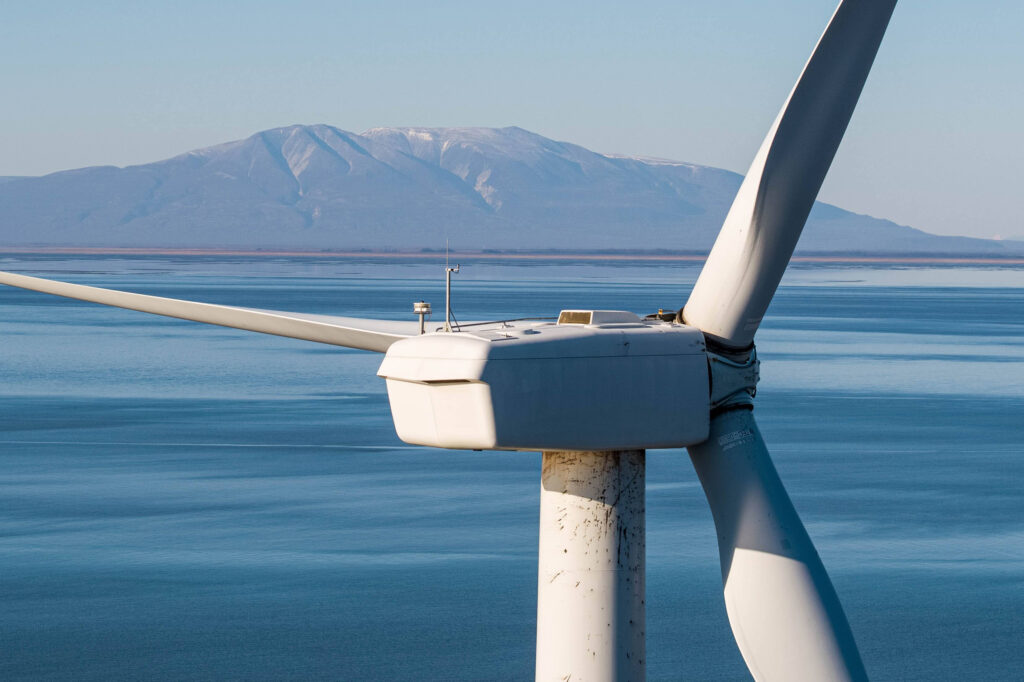 A wind turbine spins on Fire Island, a 5.5-mile island in the Municipality of Anchorage. Cook Inlet, which is shown here in the background, has some of the best wind potential in the country, and Alaska Marine Power proposes a large offshore project that would generate electricity for hydrogen. Credit: Loren Holmes/ADN