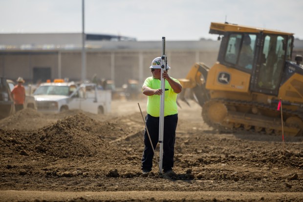 An International Union of Operating Engineers Local 150 member places a stake in the dirt at William E. Dugan Training Center in Wilmington on Sept. 20, 2024. (Tess Crowley/Chicago Tribune)