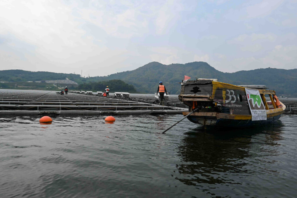 Workers at the floating solar plant dock their boat to attend to the panels. Credit: Anna McNulty/Inside Climate News