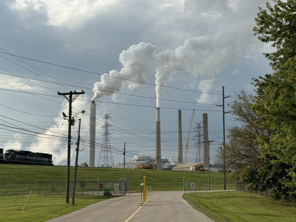 Emissions billow out of smokestacks in the distance at the power plant.