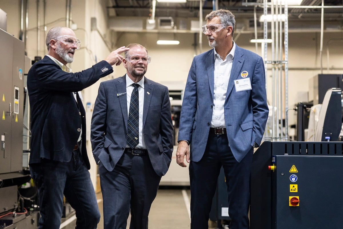 three men standing in a lab