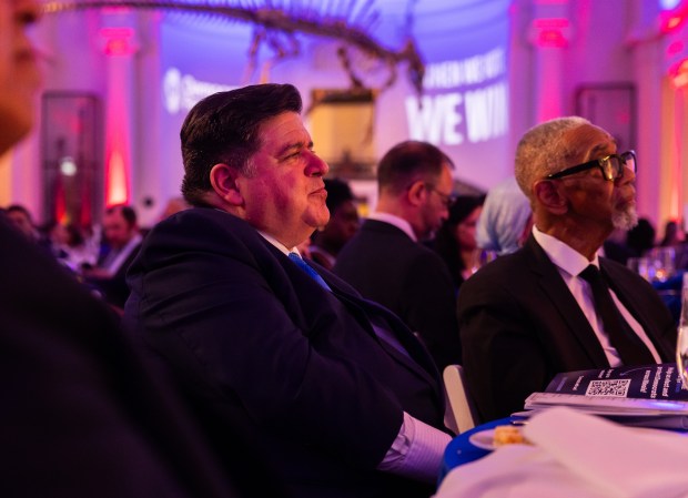 Gov. JB Pritzker, center, listens as Michigan Gov. Gretchen Whitmer speaks at the Democratic Party of Illinois' second annual gala fundraiser at the Field Museum on Sept. 27, 2024. (Tess Crowley/Chicago Tribune)