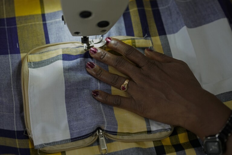 H. Gauri, 32, uses an electric sewing machine to stitch a cloth pouch in a small garage, at the campus of the Swami Vivekananda Youth Movement, a nongovernmental organization that works to help poor and Indigenous communities, in Kenchanahalli, India, Monday, Sept. 23, 2024. (AP Photo/Aijaz Rahi)