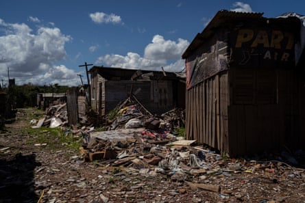 Huts of corrugated iron with debris piled up around them