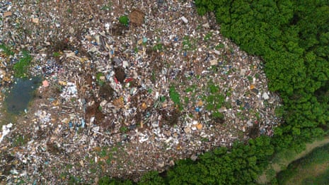 Aerial view of a huge mound of debris beside forest