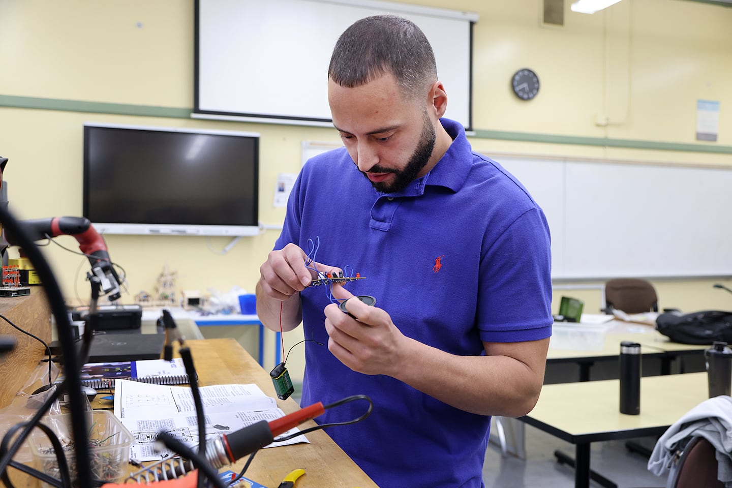 Osvaldo Medina, 37, tested one of his labs from a previous week, a circuit board connected to a speaker. When the pieces are soldered into place correctly, the speaker emits a beeping noise. 