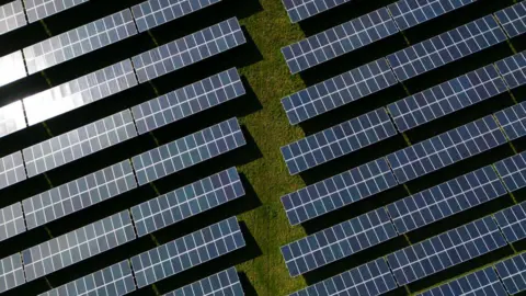 Getty Images An aerial view shows the photovoltaic (PV) solar panels making up Manston Solar Farm, in south-east England on March 18, 2024. 